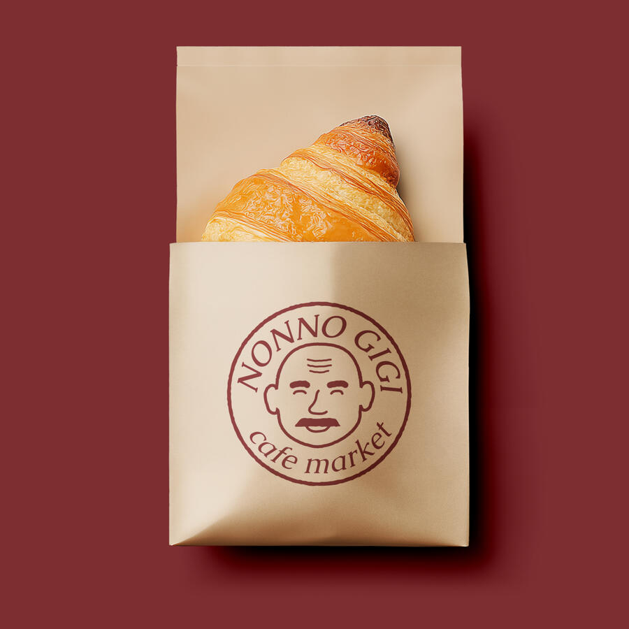 Nonno Gigi Paper Bag Mockup of a brown paper bag with a croissant inside, with the Nonno Gigi logo.
