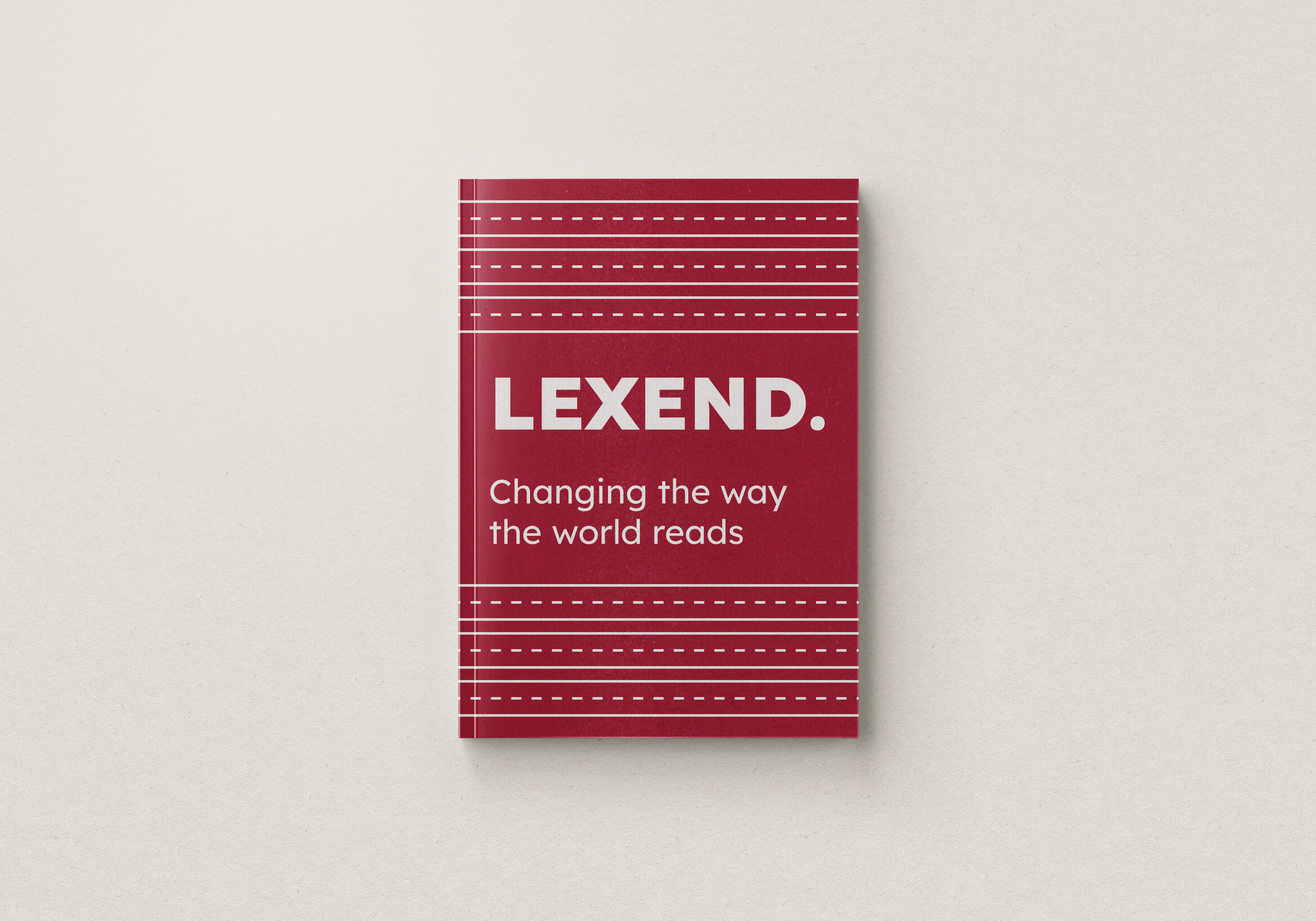 A mockup of a type specimen book cover for the typeface Lexend. A red background with horizontal white lines like a writing sheet. (Lexend. Changing the way the world reads.)